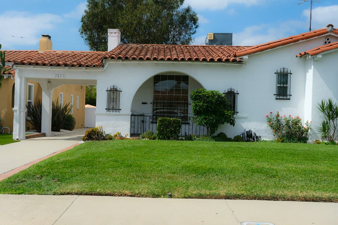 Spanish-style home with a traditional grass lawn